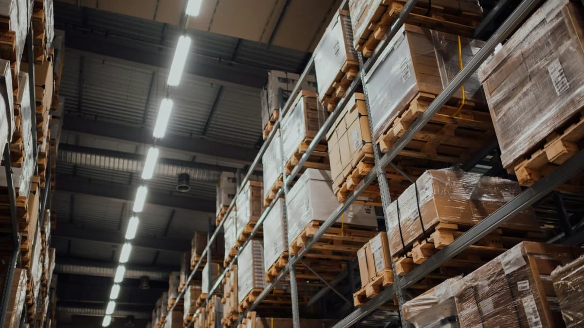 Tall warehouse racks holding pallets of cardboard cartons