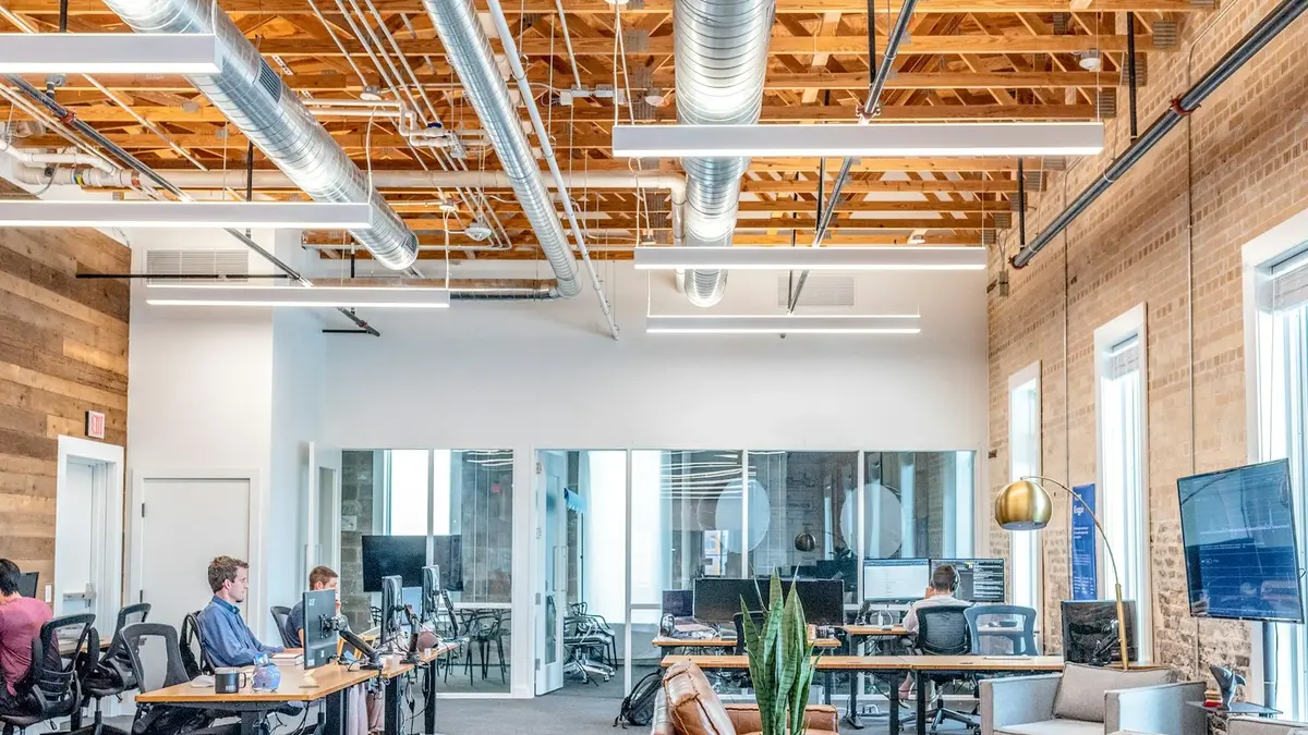 People working at computer desks in a shared office, illustrating the agency work discussed in this ClickUp versus Teamwork comparison