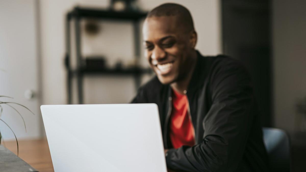A person working at a laptop beside a sunlit window